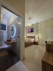 a bathroom with a sink and a bed in a room at MARESIA Rooms in Campomarino +10 photos
