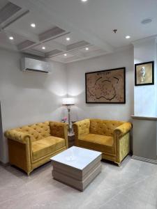 a living room with two couches and a table at Green Garden Cafe & Hotel in Amritsar