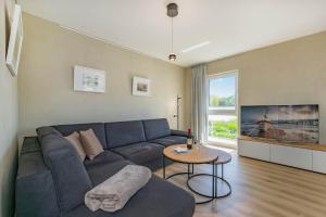 a living room with a blue couch and a table at Düneneck 11 in Zempin