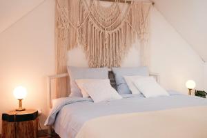 a bedroom with a white bed with white pillows at Po Prostu Dobro in Mrągowo
