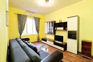 een woonkamer met een bank en een tv bij Apartment Opatija 365, steps from the sea & city center, free street parking in Opatija +3 foto's