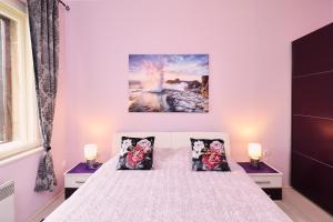 een slaapkamer met een wit bed met 3 kussens bij Apartment Opatija 365, steps from the sea & city center, free street parking in Opatija