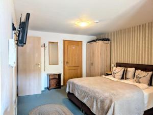 a bedroom with a bed and a flat screen tv at Familienzimmer Nr 1 im Haus Sabine in Braunlage