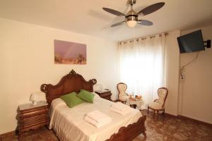 a bedroom with a bed and a ceiling fan at Casa Cándida in Almería