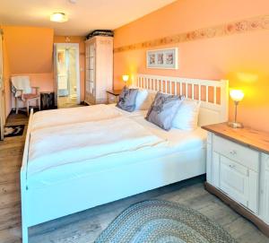 ein großes weißes Bett in einem Schlafzimmer mit orangefarbenen Wänden in der Unterkunft Haus Sabine - Zimmer 2 in Braunlage