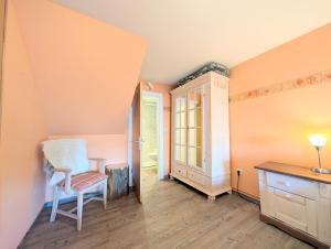 Zimmer mit einem Stuhl, einem Schreibtisch und einem Fenster in der Unterkunft Haus Sabine - Zimmer 2 in Braunlage