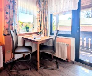 einen Tisch und zwei Stühle in einem Zimmer mit Fenster in der Unterkunft Haus Sabine - Zimmer 2 in Braunlage + 12 Fotos