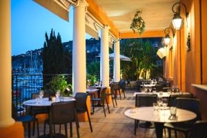 a restaurant with tables and chairs on a patio at Hotel De La Darse in Villefranche-sur-Mer