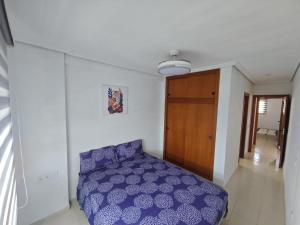 a bedroom with a purple bed and a wooden door at Oasis en la playa de Albir Apartamento in Albir +16 photos