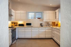 a white kitchen with white cabinets and appliances at Villa Opale in Trou d'Eau Douce