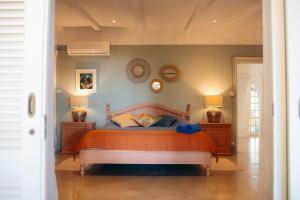 a bedroom with a bed and two lamps and two mirrors at Villa Opale in Trou d'Eau Douce