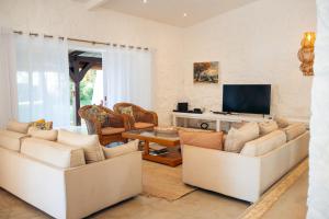 a living room with two white couches and a tv at Villa Opale in Trou d'Eau Douce