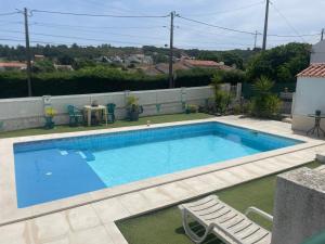 een zwembad met twee stoelen en een tafel bij Casa Vila Sao & Pompeia in Sesimbra