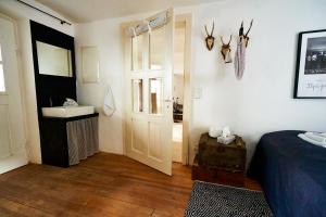 グラッサウにあるWASCHHAUS - Ferienhaus in Grassau im Chiemgauのベッドルーム1室(ベッド1台、シンク、ドア付)