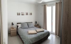 a bedroom with a bed with two pillows on it at La Maison Blanche in Arles