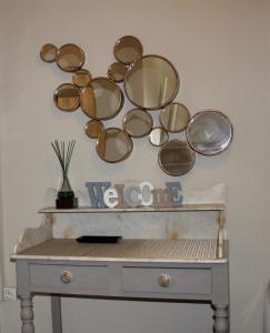 a group of glasses on a wall above a dresser at La Maison Blanche in Arles