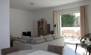 ein Wohnzimmer mit einem weißen Sofa und einem Tisch in der Unterkunft La Maison Blanche in Arles