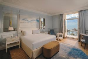 a bedroom with a large white bed and a balcony at Fairmont Le Montreux Palace in Montreux