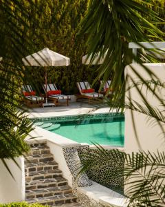 a swimming pool with two lounge chairs and an umbrella at Kassandra Boutique Hotel in Oludeniz