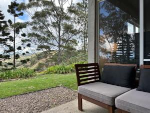 eine Couch auf der Veranda eines Hauses in der Unterkunft Maleny-Montville Cottages #2, 2 bed with ocean views in Balmoral Ridge