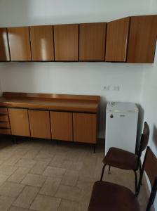 a kitchen with wooden cabinets and a table and chairs at Sognando Ostuni in Ostuni
