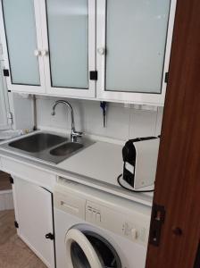 a kitchen with a sink and a washing machine at Sognando Ostuni in Ostuni