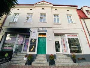 budynek z zielonymi drzwiami na ulicy w obiekcie Apartament Studio 11 Starówka Konin w Koninie