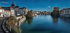 a river in a city with buildings and a bridge at Studio Platanes 8 - Proche Disneyland - Parking gratuit - Meaux in Meaux