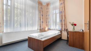 a small bedroom with a bed in front of a window at Hotel Samechov - konferenční hotel in Samechov