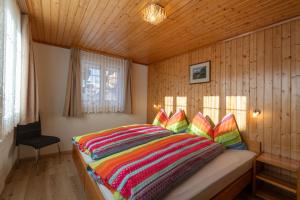 a bedroom with a bed with a colorful comforter at Chalet Alpenheim 2 OG in Bettmeralp