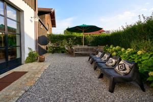 グラッサウにあるWASCHHAUS - Ferienhaus in Grassau im Chiemgauのパティオ(ベンチ、パラソル付きテーブル付)