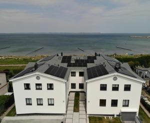 グロヴェにあるAloha Paradies erste Strandlinie mit direktem Meerblick im Neubau, Glowe, Ostseeの屋根に太陽光パネルを設置した白い家々の集まり