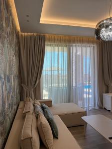 a bedroom with a bed and a large window at Turquoise Pool Side Thymus Resort in Himare