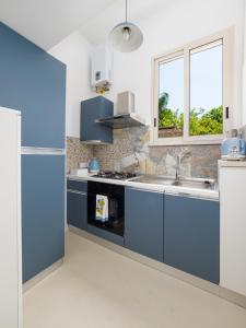 a kitchen with blue cabinets and a sink at EMMEhouse in Sant'Agnello