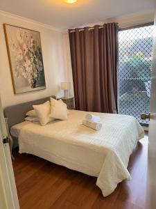 a bedroom with a large bed with a window at rental in surry hills perfect for groups in Sydney