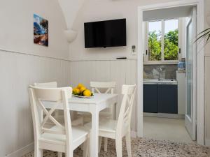 a white dining room with a white table and chairs at EMMEhouse in Sant'Agnello