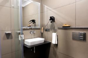 ein Badezimmer mit Waschbecken und Spiegel in der Unterkunft Hotel Kyzen - Hitec city, Hyderabad in Hyderabad + 116 Fotos