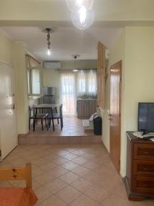 Una sala de estar con una mesa y una cocina. en Lianna Apartment, en Nikiti