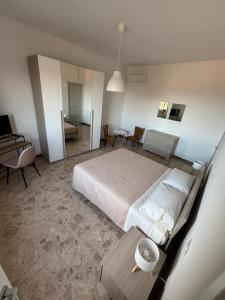 a bedroom with a large bed and a table with a table at BB Da Primo la vista sul borgo Potenza Picena in Potenza Picena +10 photos