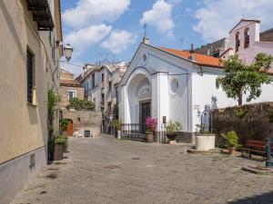a small white building with an arch in a street at EMMEhouse in Sant'Agnello