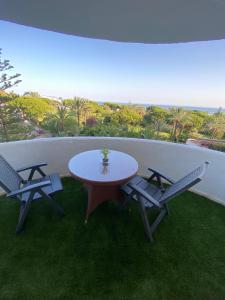 a table and two chairs on a balcony with the ocean at Marbella Beach View and Pool in Marbella