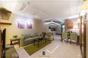 un salon avec un canapé et une table dans l'établissement شقق لمار الغرب الفاخرة, à Djeddah