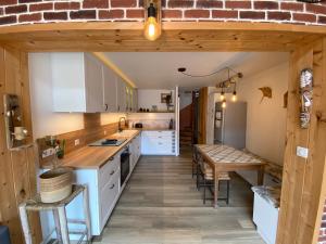 a kitchen with white cabinets and a table and chairs at Nid chaleureux proche de l'océan in Lacanau