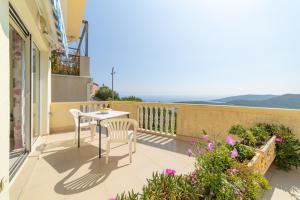 a patio with a table and chairs on a balcony at Apartments Dragičević 6 with Garage in Budva
