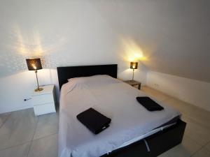 a bedroom with a large white bed with two lamps at Villa Des palmes - piscine privée au bord du Lagon de la Saline in Saint-Paul +51 photos