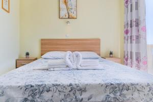 a bedroom with a bed with towels on it at Apartments Dragičević 6 with Garage in Budva