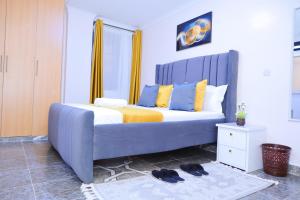 a large bed with a blue headboard in a bedroom at 1 bedroom in Kamakis in Ruiru