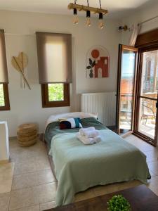 a bedroom with a bed with two towels on it at Niki's Paradise View in Taxiarchis