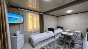 ein Krankenhauszimmer mit 2 Betten und einem Flachbild-TV in der Unterkunft УЮТ отель и хостел in Jalal-Abad