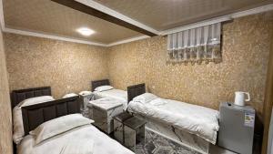 eine Gruppe von 4 Betten in einem Zimmer in der Unterkunft УЮТ отель и хостел in Jalal-Abad + 42 Fotos